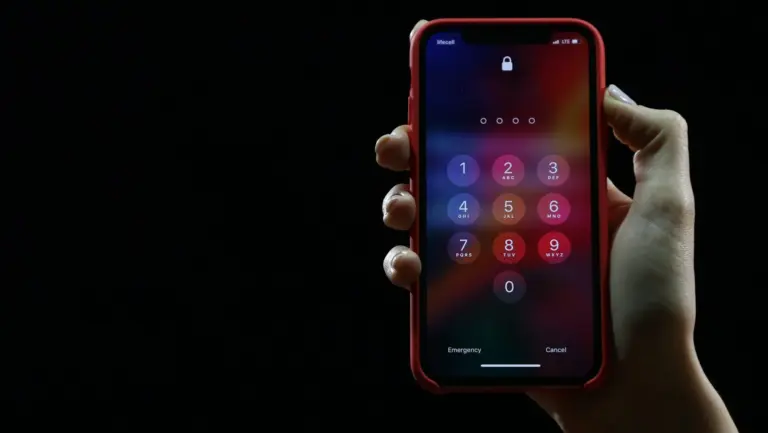 Uma garota segura um iPhone protegido por senha na mão.